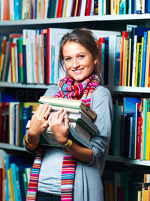 Young smiling lady holding books in library