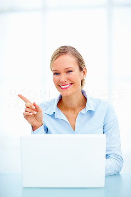 Young business person using laptop , pointing at space to copy