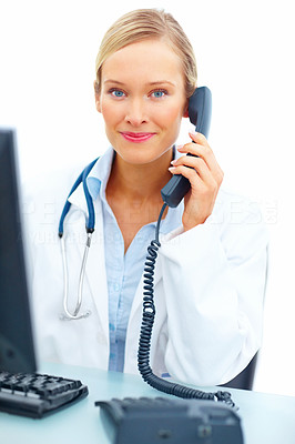 Portrait of young female doctor using telephone at desk