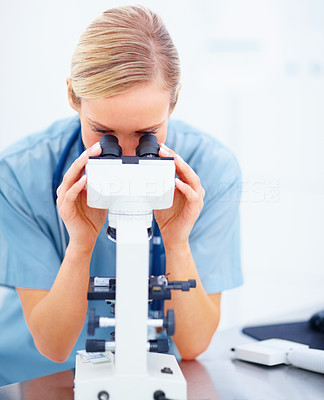 Young doctor using microcope on white background