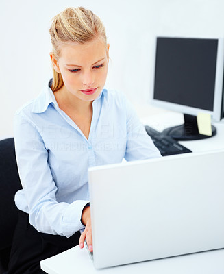 Young woman sitting in office typing on laptop