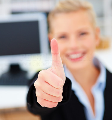 Smiling young businesswoman giving thumbs up
