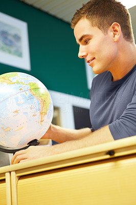 Modern student looking at globe of the world