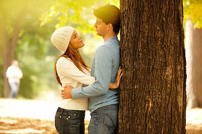 Couple standing against a tree and hugging