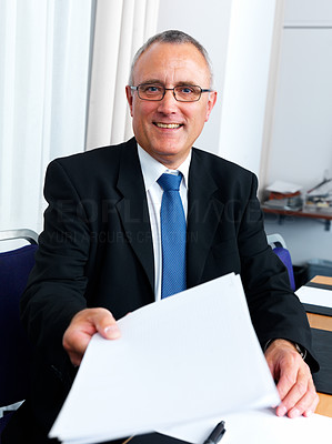 Senior business man in office holding paper in hand