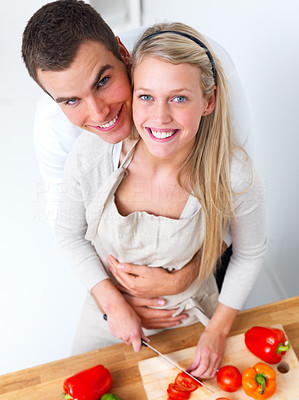 Happy romantic couple preparing food in kitchen
