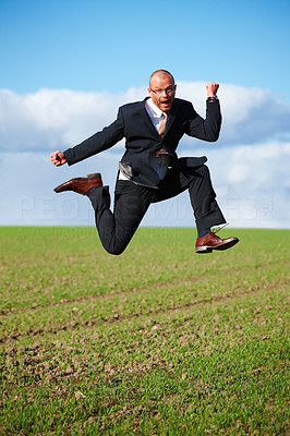 Ambitions - Businessman jumping in a field