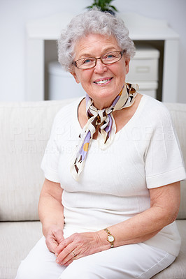 Closeup of an old woman sitting on a sofa and smiling
