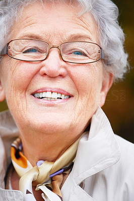Closeup of a happy senior woman wearing glasses and smiling