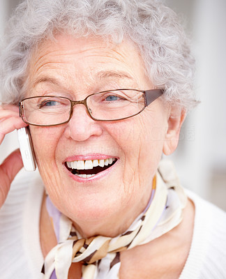 Closeup of an old woman smiling and using a cellphone