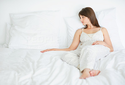 Sad young woman missing somebody on bed