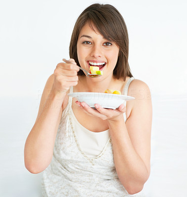 Cute young female eating fruit salad