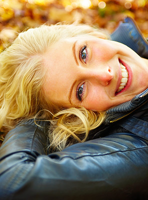 Woman lying on ground looking up and smiling