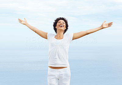 Cheerful young woman with spreading arms to sky