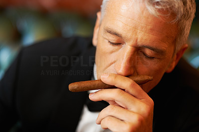 Rich man smelling cigar