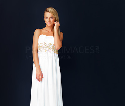 Beautiful young woman dressed in white evening gown