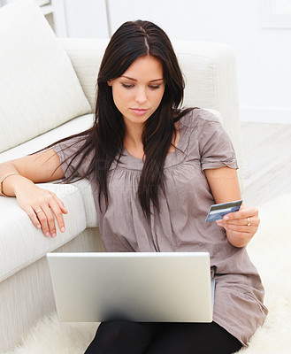 Young woman using laptop and holding credit card