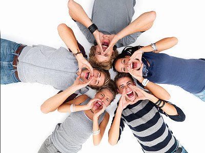 Happy young friends lying on white floor and shouting