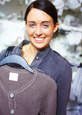 Happy young woman purchasing clothes in store