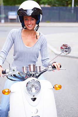 Closeup of a happy woman riding a motorcycle on the street
