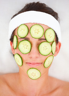 Closeup of cucumber slices on a young girl\'s face