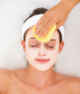 Closeup of a facial mask treatment being wiped off the face isolated on white