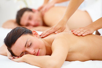 Smiling naked young woman getting back massage at day spa
