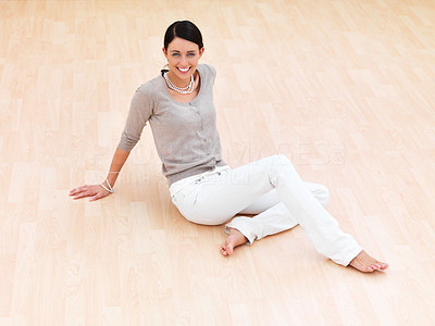 Happy young woman sitting on floor