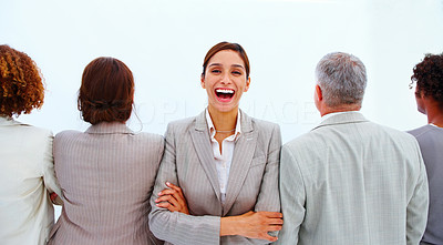 Portrait of a business woman laughing with executives against white background