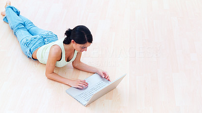 Young lady lying on floor using laptop