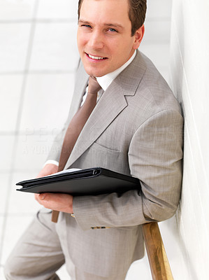 Successful handsome business standing, holding a folder