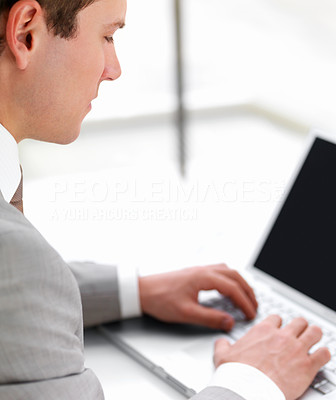 Successful handsome business man working on computer against white background