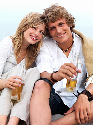 Young couple sitting together with beer bottles