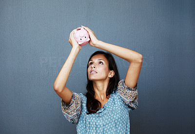 Bankruptcy - Young woman checking piggy bank for money