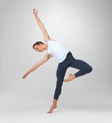 Male ballet dancer performing a balancing act against white