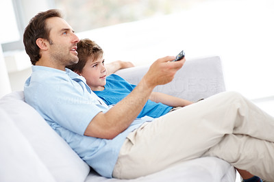 Relaxed father and son watching television together