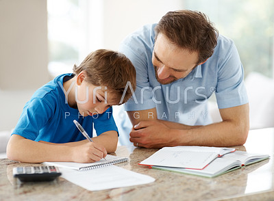Happy man helping his son to do homework