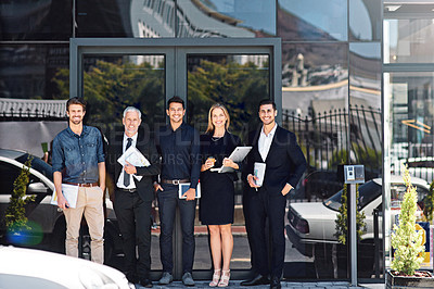 Buy stock photo Portrait of a team of happy professionals standing in front of a modern office building