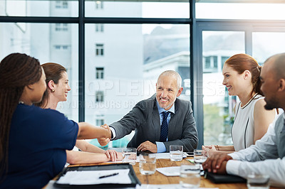 Buy stock photo Cropped shot of two businesspeople shaking hands during a meeting