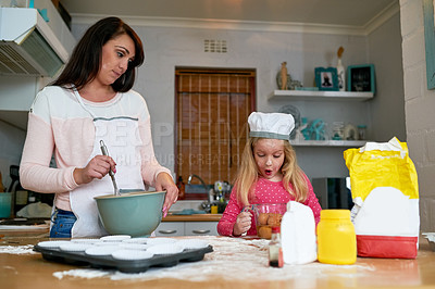 Buy stock photo Cropped shot of a little girl baking in the kitchen with her mom