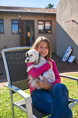 Buy stock photo Portrait of a happy little girl sitting on a chair and holding her pet dog outdoors