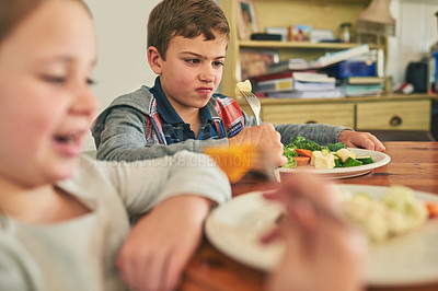 Buy stock photo Cropped shot of two grumpy children refusing to eat their vegetables
