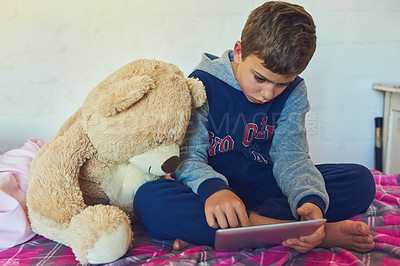 Buy stock photo Shot of a young boy using a digital tablet at home