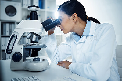 Buy stock photo Shot of a young scientist using a microscope in a laboratory