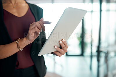 Buy stock photo Cropped shot of an unrecognisable businesswoman standing alone in the office and using a digital tablet