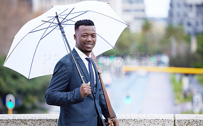 Buy stock photo Shot of a young businessman holding an umbrella in the rain against a city background