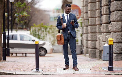 Buy stock photo Shot of a young businessman using a phone in the city