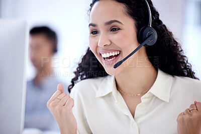 Buy stock photo Shot of a young call centre agent cheering while working on a computer in an office