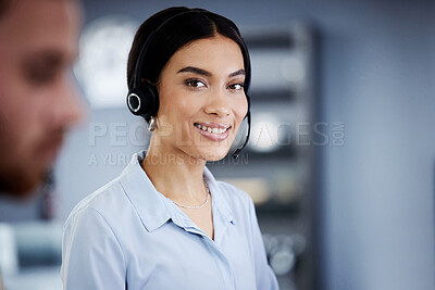 Buy stock photo Shot of an attractive young call centre agent sitting with her colleague in the office