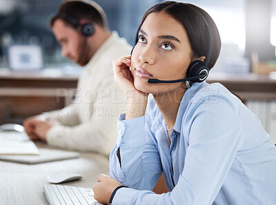 Buy stock photo Shot of a young call centre agent sitting in the office with her colleague and feeling bored